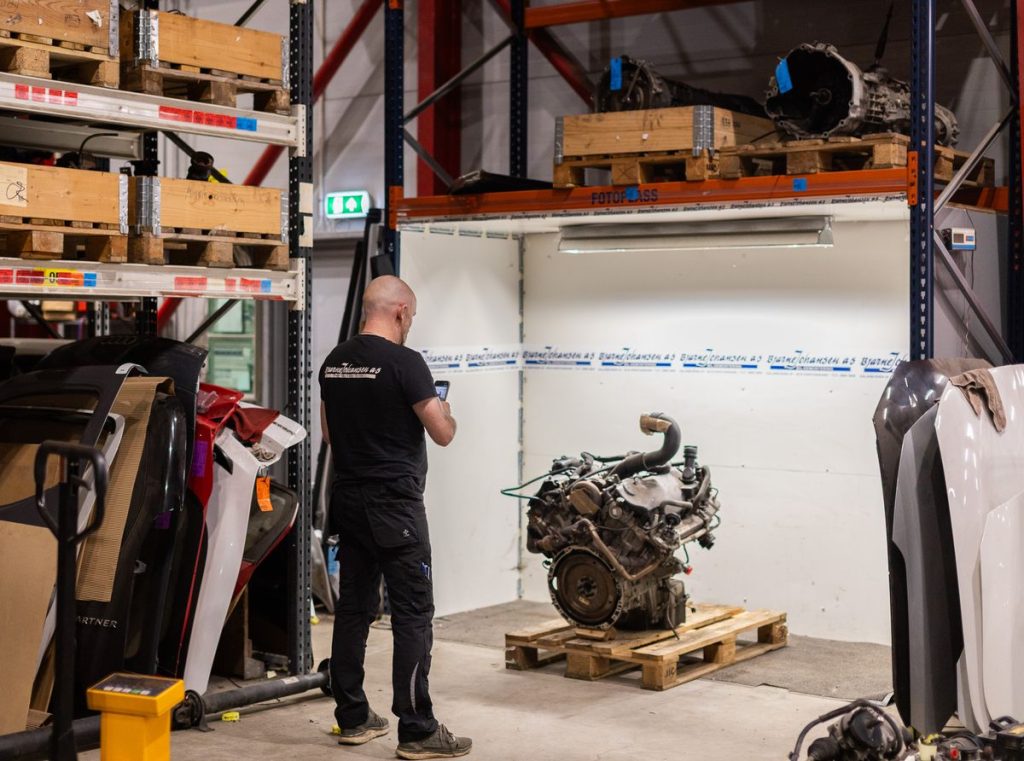 Tekniker med en demontert motor på pall