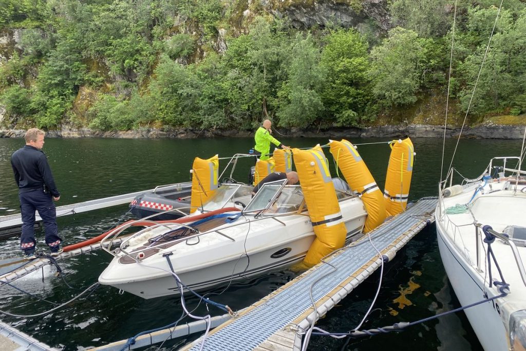 Båten flyter igjen ved flytebrygga, med løftesekkene fortsatt festet langs siden